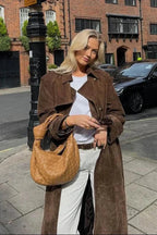 Brown womens trench coat with lapels and belt, model wearing over white top