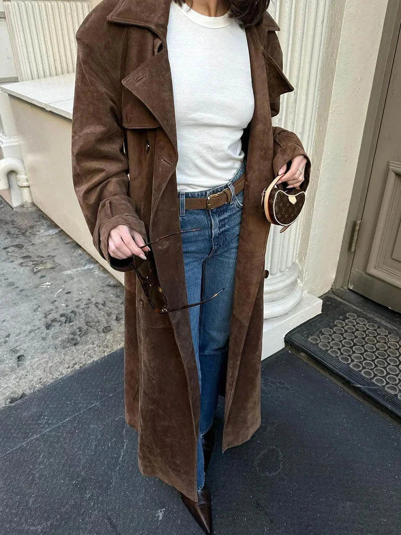 Brown womens trench coat with lapels and belt, styled open over jeans