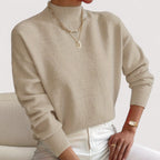 Beige women’s loose-fit sweater, crew neck, long sleeves, ribbed cuffs and hem.