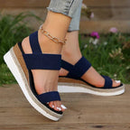 Navy blue platform sandals with textured elastic straps, open toe, cushioned wedge sole