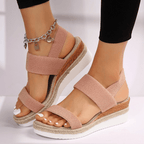 Blush pink platform sandals with elastic straps and open toe, chain ankle detail
