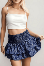 Leilani tiered mini skirt in dark blue patterned fabric with smocked waist and ruffles.