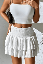 Leilani tiered mini skirt in white with gathered ruffle tiers and smocked waistband.