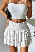 White tiered mini skirt with layered ruffle skirt panels and elastic waist