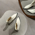 Cream pointed-toe ankle boots with chunky heels, shown from above