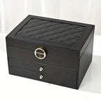 Black multilayer leather jewelry box with quilted top, gold lock, and two drawers