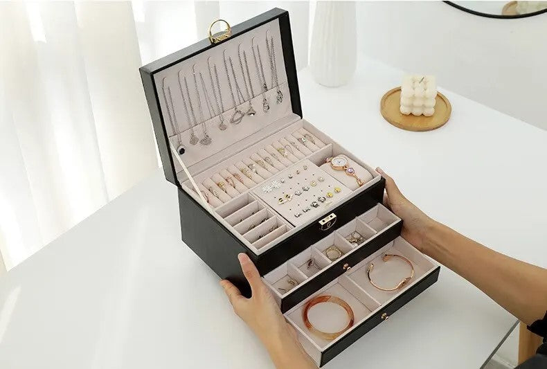 Black leather multilayer jewelry box open with jewelry slots and stacked drawers
