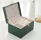 Green leather jewelry box open with necklace hooks and ring display tray