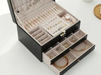 Black multilayer leather jewelry box open with ring holders, earring slots, and drawers