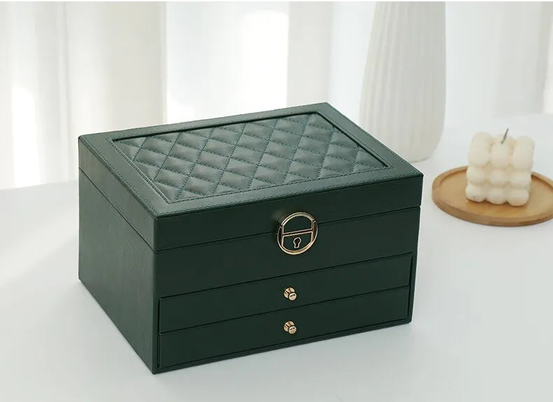 Green multilayer leather jewelry box with quilted top, gold lock, and two drawers