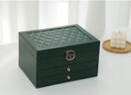 Green multilayer leather jewelry box with quilted top, gold lock, and two drawers