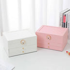 Two multilayer leather jewelry boxes: white and pink with gold locks and two drawers