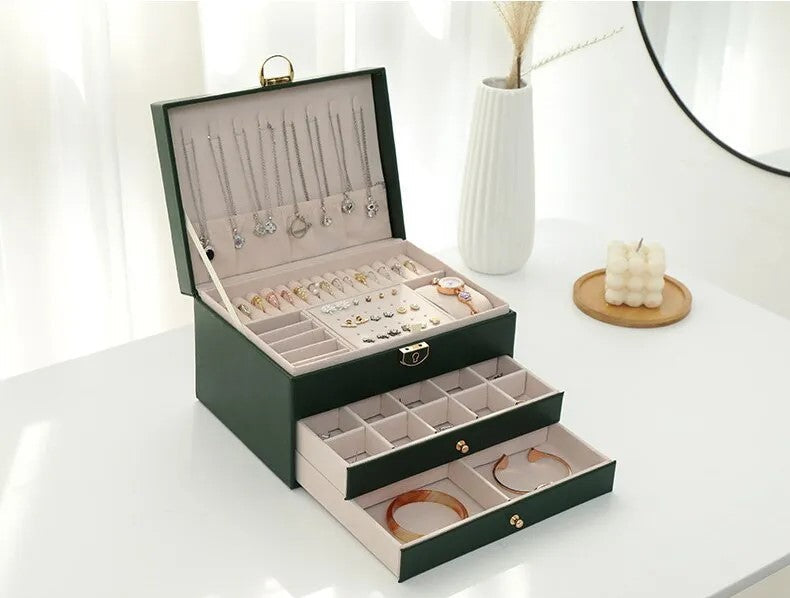 Green leather jewelry box open with necklace slots and drawer compartments