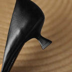 Black pointed-toe kitten heels, angled side view with low block heel