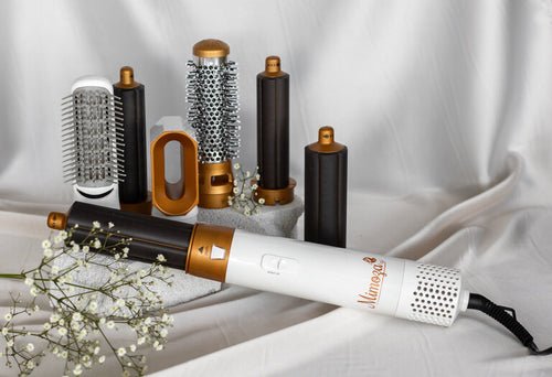 Hair dryer brush styler kit with white handle, gold barrels, and multiple styling attachments