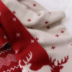 Red and cream knit scarf close-up with reindeer motif and patterned knit texture