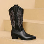 Women’s embroidered pointed-toe cowgirl boots in black with block heel and leaf-style embroidery.