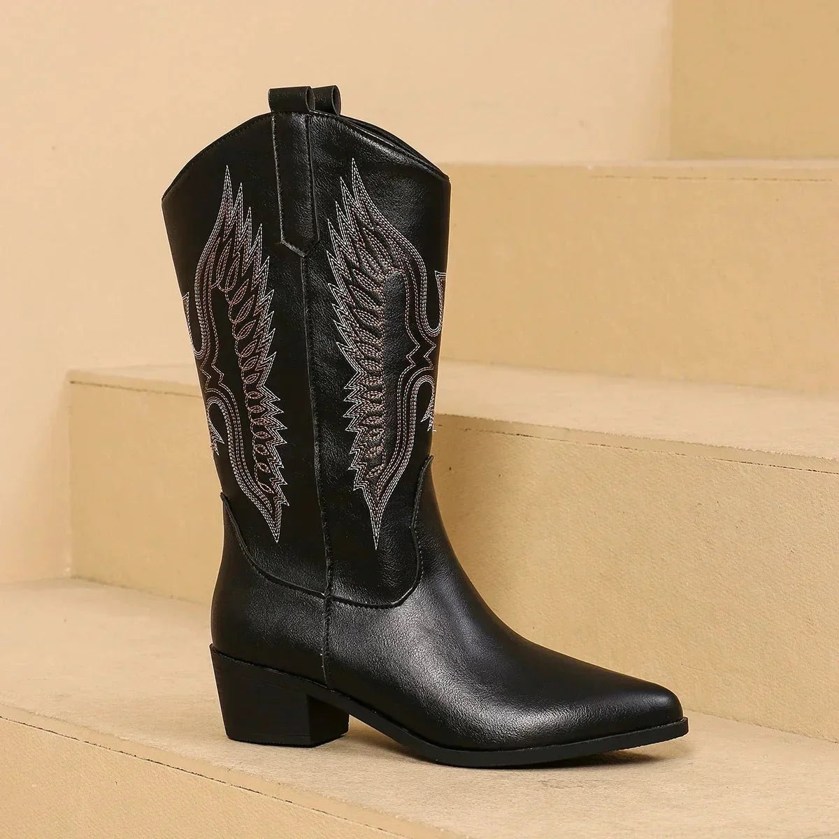 Women’s embroidered pointed-toe cowgirl boots in black with block heel and leaf-style embroidery.