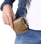 Leather RFID bifold wallet with coin pocket, tan held in a hand with jeans pocket