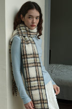 Plaid wool scarf draped on shoulders, off-white with dark lines and fringes