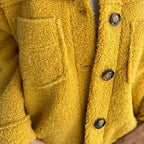 Close-up of yellow button-front sherpa cardigan with two flap chest pockets