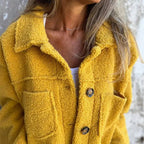 Yellow collared cardigan with button front and flap pockets in textured fuzzy fabric
