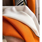 Folded oversized scarf with orange and white textured weave and dark navy edge trim