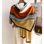 Oversized winter scarf in orange, tan, and white with black striped chevron border