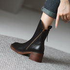 Women’s black leather heeled booties with side zipper, tassel pulls, and wood-look block heel.
