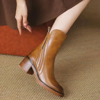 Women’s tan leather booties with side zipper, tassel accents, and stacked block heel.