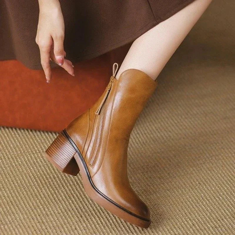 Women’s tan leather booties with side zipper, tassel accents, and stacked block heel.