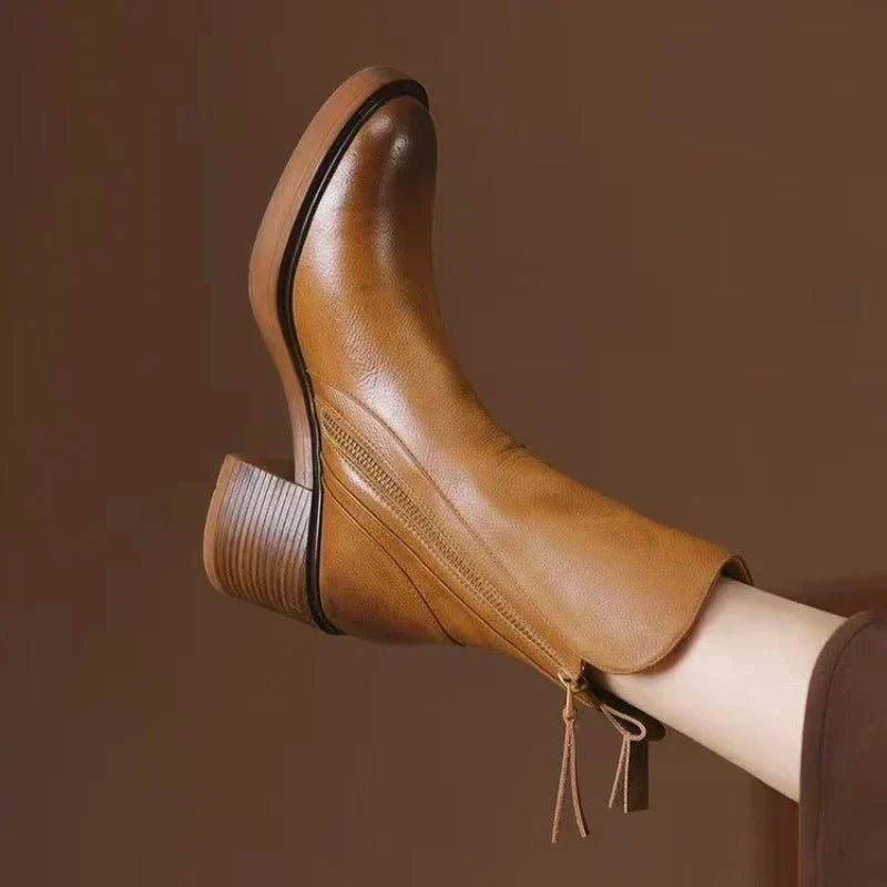 Women’s heeled block-heel booties in tan leather with side zipper and ribbed cuff.