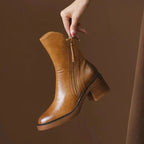 Women’s tan leather heeled booties with side zipper and tassel pull, stacked block heel.