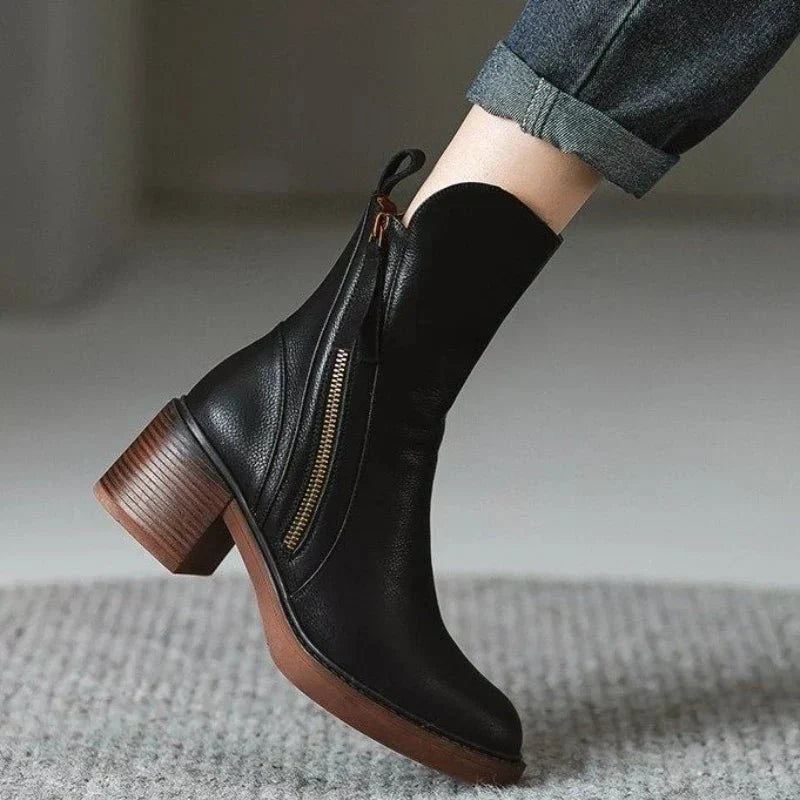 Women’s black leather ankle booties with side zipper, tassel pulls, and chunky block heel.