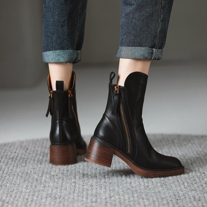 Women’s black ankle booties with side zipper and tassel pulls, showing chunky block heel.