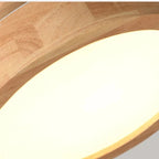 Close-up of circular wood ceiling lamp rim around the bright LED diffuser