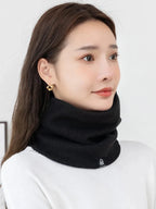 Black ribbed neck warmer scarf with plush lining worn high on the neck