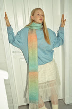 Gradient knit scarf with teal, green, and peach bands and long fringes