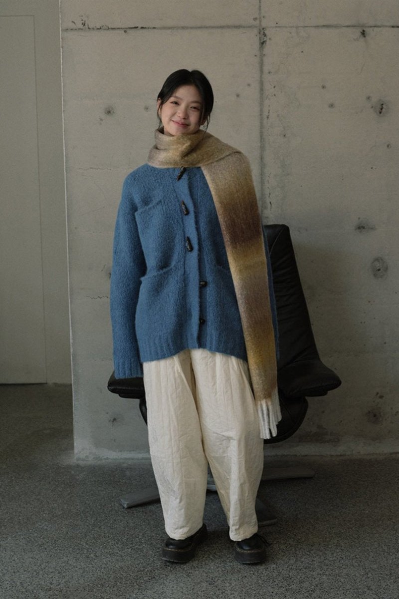 Long gradient knit fringe scarf, blue to brown, draped over shoulders