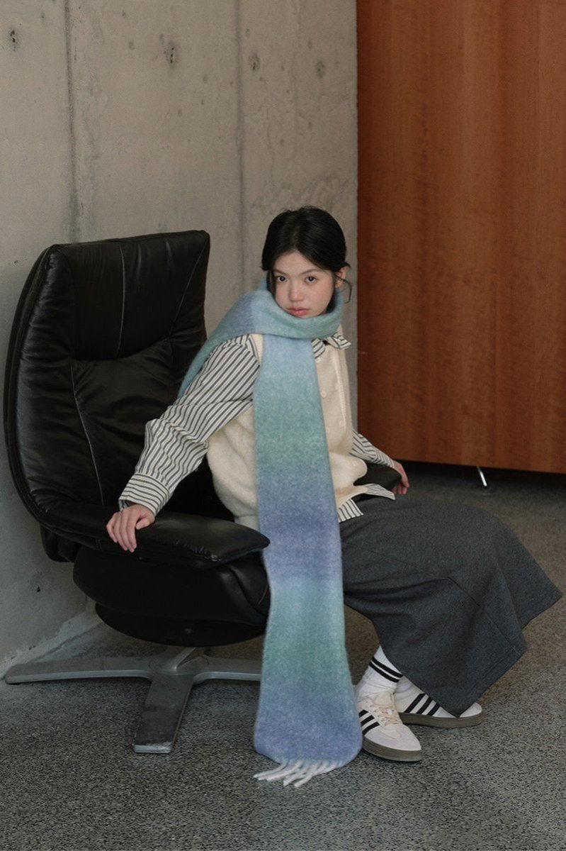 Light blue gradient knit scarf wrap with long fringed ends and striped trim
