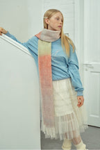 Gradient knit scarf with pastel pink, peach, and green panels and long fringes