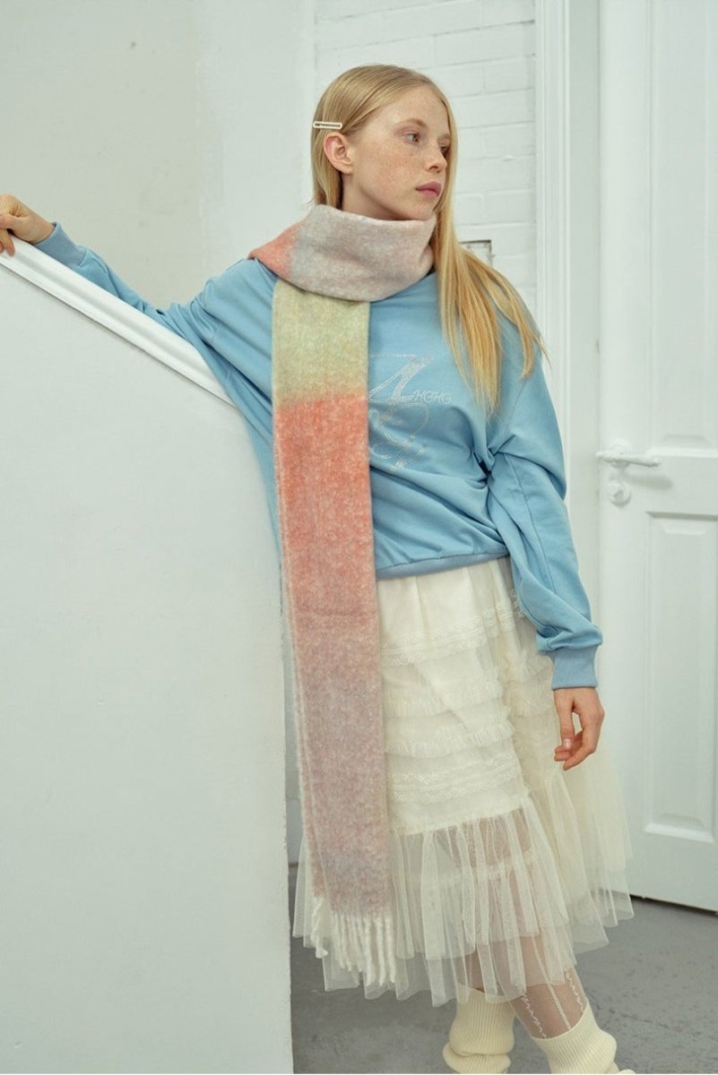 Gradient knit scarf with pastel pink, peach, and green panels and long fringes