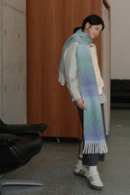 Light blue gradient knit scarf wrap with striped trim and long fringe ends