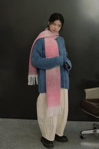Long knit gradient scarf with pink center, blue sides, and fringed ends