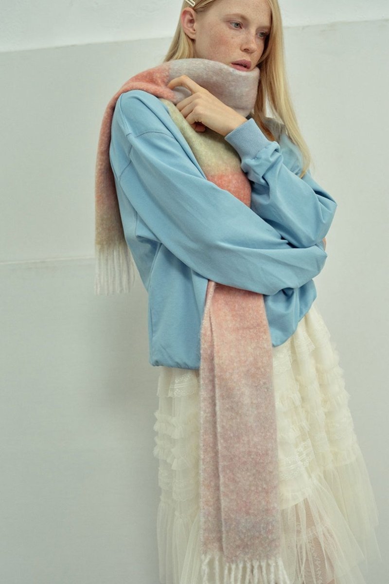 Gradient knit scarf in pastel pink and peach tones with long fringes