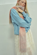 Gradient knit scarf in pastel pink and peach tones with long fringes
