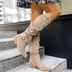 Beige knee-high slouch boots with low block heel and cuff strap detail