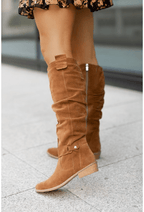 Light brown knee-high slouch boots with low block heel and cuff strap detail
