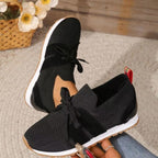Women's lightweight slip-on sneakers, black knit with bow laces and white sole