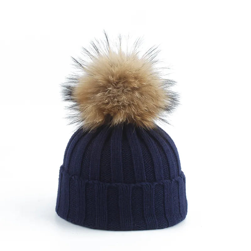 Knit beanie hat with tan pom-pom, ribbed texture, navy color